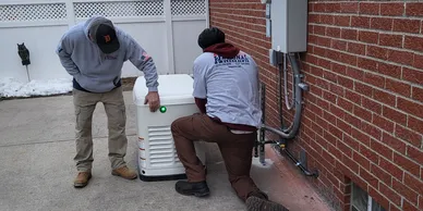 Two men working on a small air conditioner.